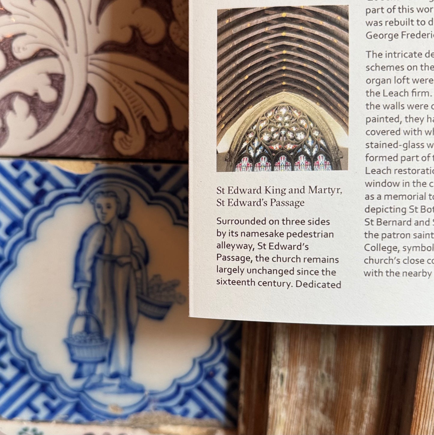 Close-up of decorative tiles with intricate patterns and a text overlay on a wooden surface.