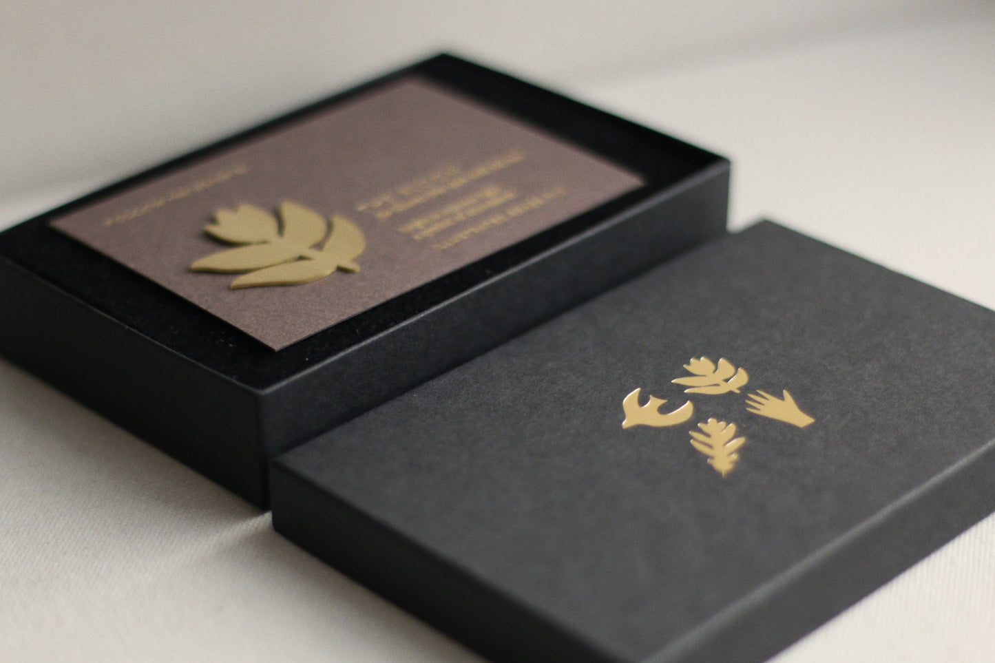 Black boxes with gold leaf designs on a light gray background