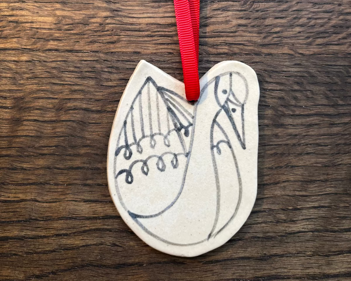Decorative pendant with a red ribbon on a wooden surface